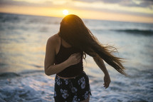 woman on a beach tossing her hair 