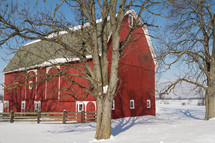 snow over a red barn 