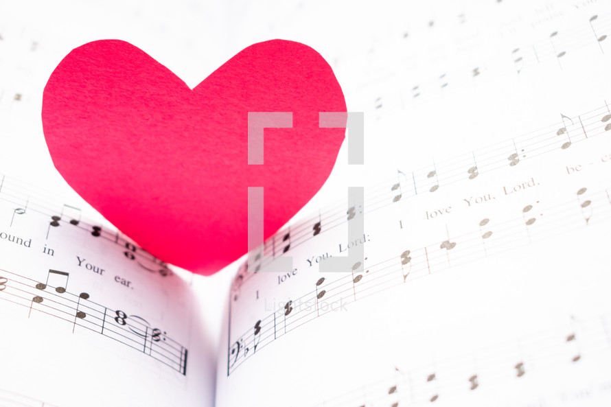 red paper heart on sheet music 
