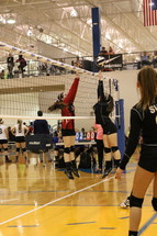 high school girls playing competitive volleyball 