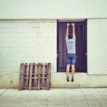 man hanging from a barred door 