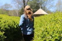 a woman running through bushes 