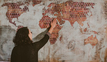 a woman with her hands on a world map 