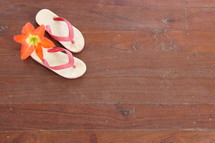 Child's flip flops on wooden floor with tropical flower orphan orphanage mission 
