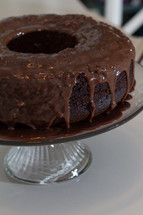 A chocolate bundt cake on a cake stand.