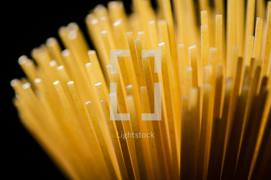 A pile of spaghetti dry on the table. Against a dark background. High quality photo