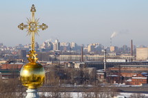 Cross on a cathedral overlooking a sprawling city