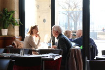 mature couples sitting in a restaurant in conversation 