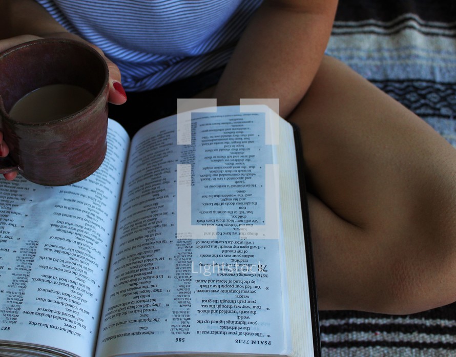 a girl reading a Bible and drinking coffee 