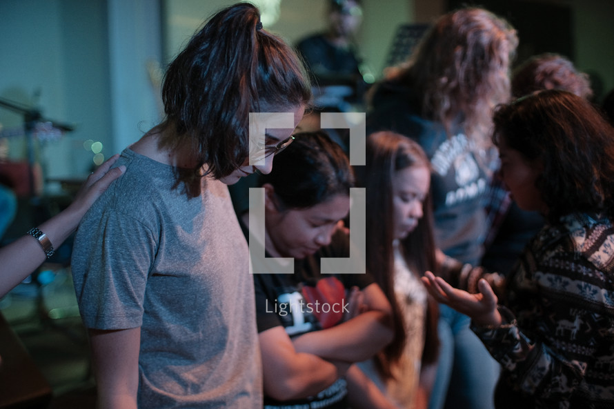 young women praying together 