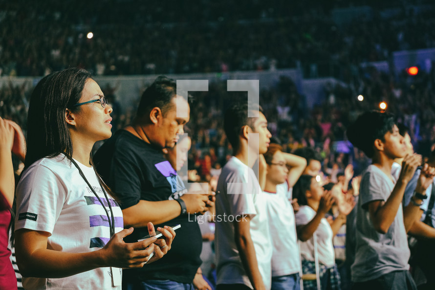 people in a stadium worshiping God 