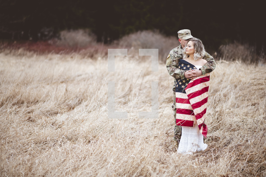 military couple wrapped in an American flag