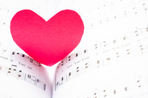 red paper heart on sheet music 