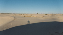 silhouettes standing on sand dunes 