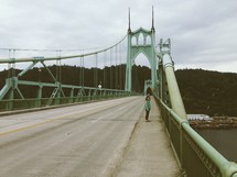 woman looking over the side of a bridge 