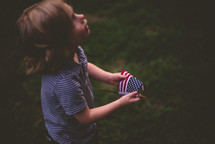 a toddler holding an American flag 