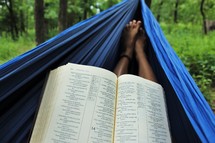reading a Bible in a hammock 