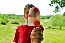 a boy holding a popsicle 