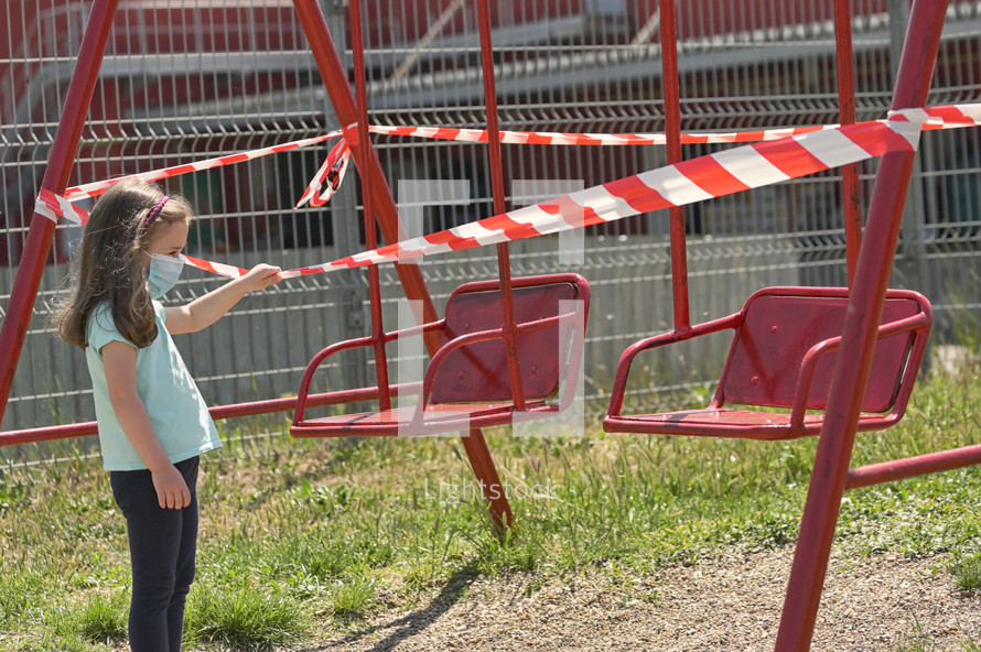 Girl and Children's Swings Wrapped With Signal Tape