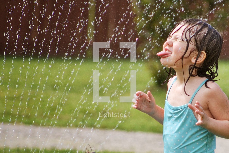 girl child playing in a sprinkler