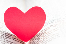 red paper heart between the pages of a Bible 