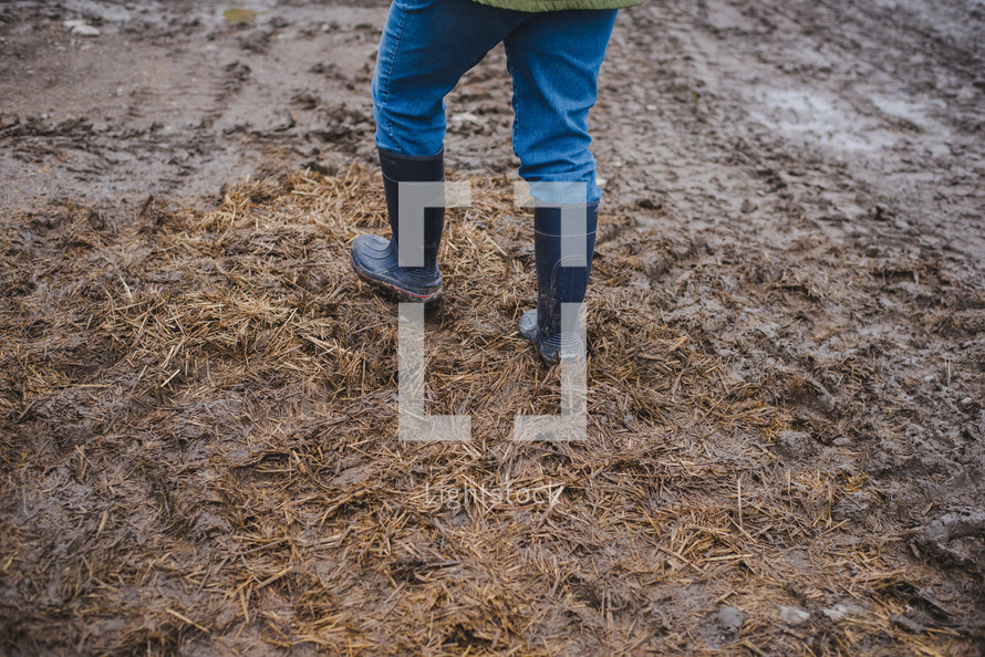 rain boots walking through mud on a farm 