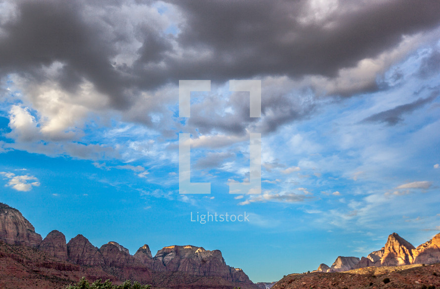 clouds over red mountain cliffs 