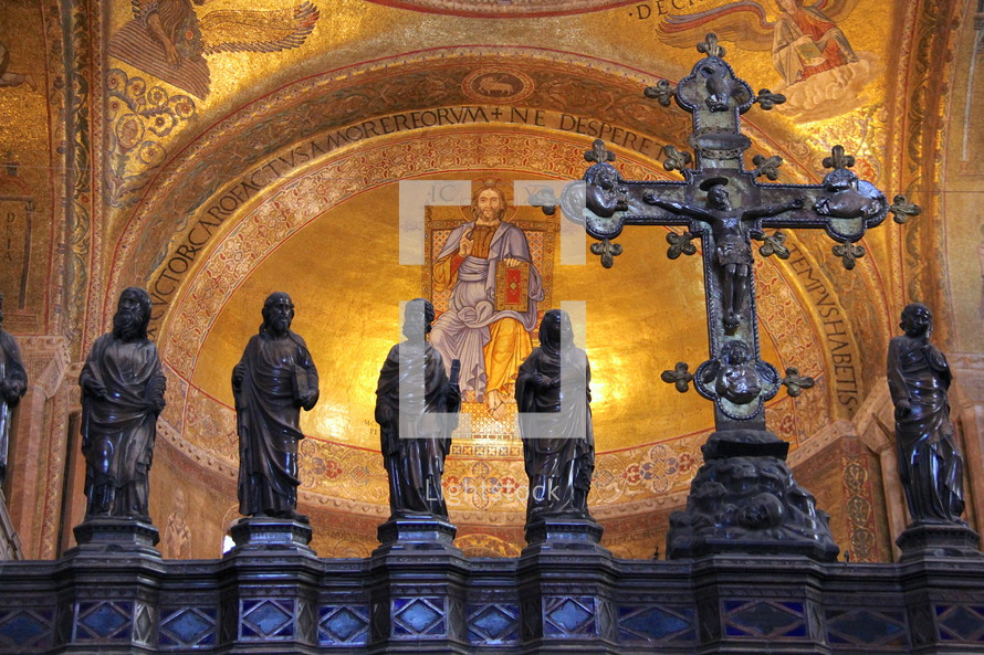 Decorative cross with statures of disciples and saints in a cathedral dome.