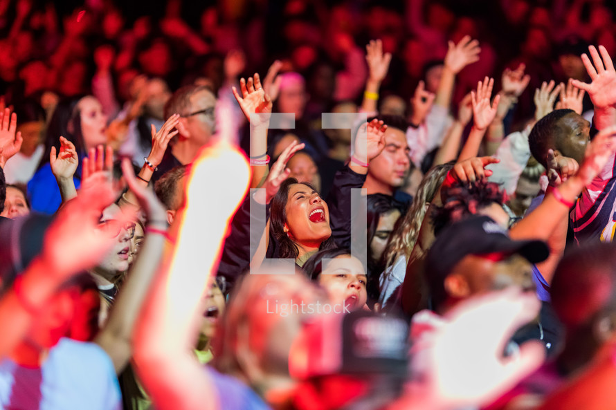 people singing with raised hands at a Christian Concert 