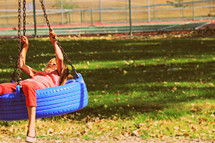 child on a tire swing 