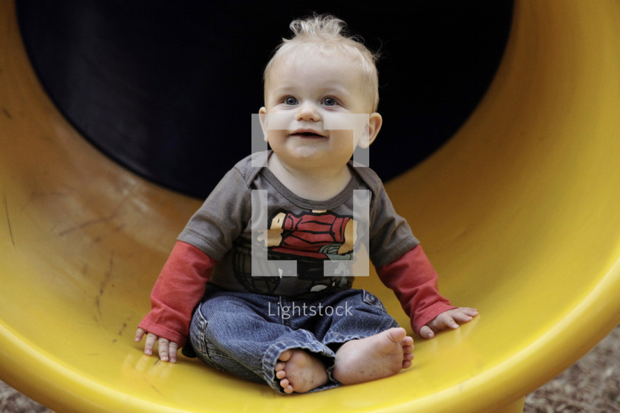 infant boy on a slide 
