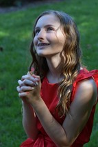 teen girl looking up to God with praying hands 