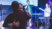 hugs on stage during a worship service 