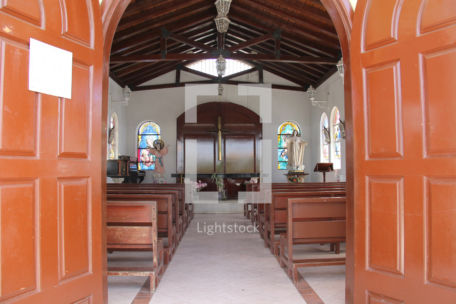 Church sanctuary with wooden pews and beams.