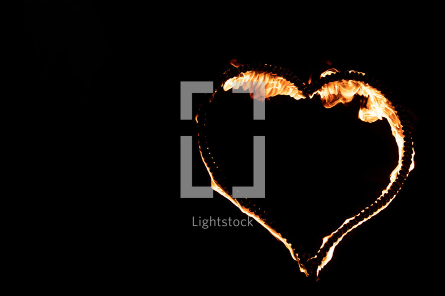 Burning heart with flames. Isolated on dark background. fire show in night. happy valentine's day card. bengal fire burning heart. space for text. wedding or valentine concept. happy new year