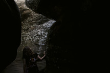 a young woman exploring a cave 