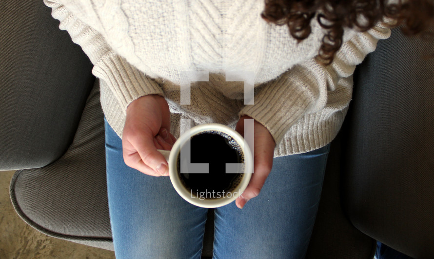 woman holding a coffee mug in her lap 