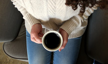 woman holding a coffee mug in her lap 