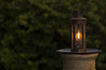A garden oil lamp with vegetation background and copy space