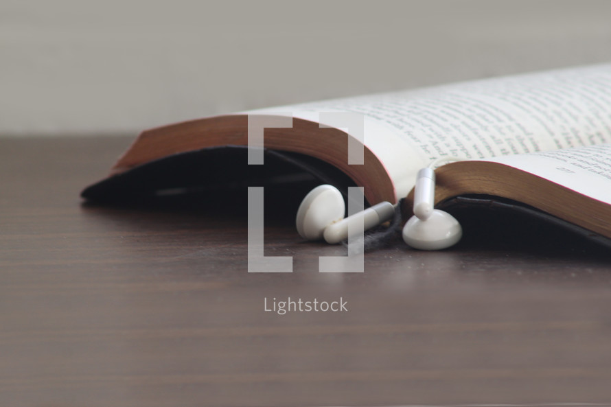 earbuds marking the page of a Bible 