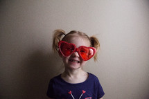 a child in heart shaped sunglasses 