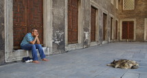 A Muslim man and his dog sleeping inside the courtyard of the Blue Mosque, Istanbul.