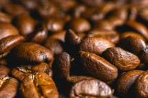 Close up from a bunch of coffee beans laying down. Backdrop for coffee products.