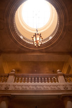 chandelier hanging from a sky light in a grand building 