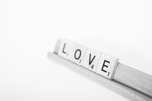 Scrabble tiles spelling "love."