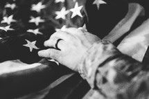 serviceman with hand on an American flag