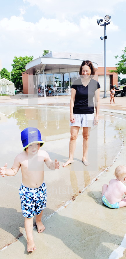 mother and kids at a splash pad 