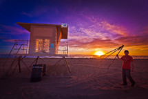 lifeguard stand at sunset and a man with a tripod