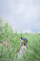 a woman standing in a field of tall grasses 