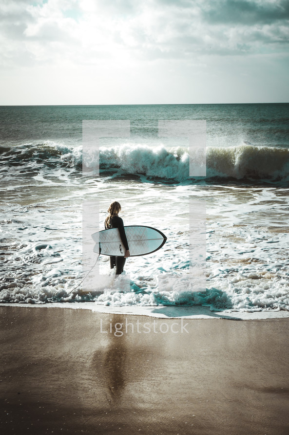 surfer standing on a beach 